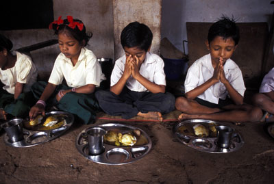 children praying before eating a meal