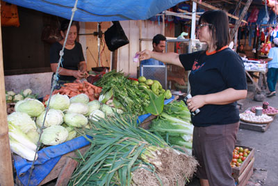 woman buying vegetables at a street market