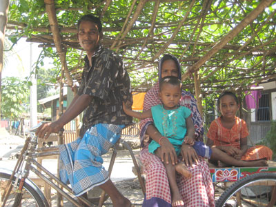 young man riding cargo bike with woman and two children on back of bike