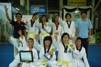 martial arts team celebrating with trophies and certificates