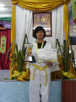 girl holding trophy and certificate for martial arts