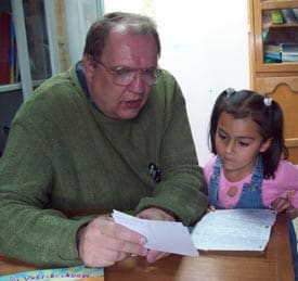 man reading a letter to a little girl