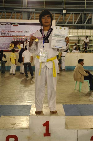 girl holding first place medal and certificate for martial arts