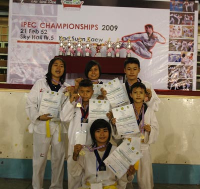 children holding up medals and certificates for martial arts