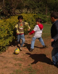 three boys playing soccer