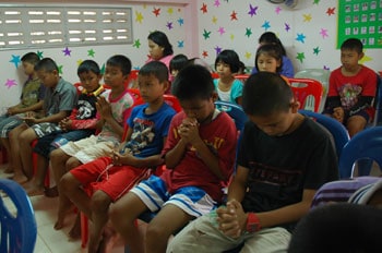 group of children sitting and praying