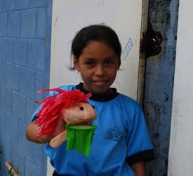 Young child holding a puppet.