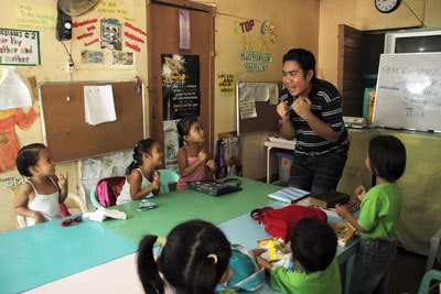 man teaching children in classroom