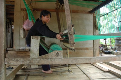 woman working on a fabric loom