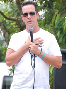 man in sunglasses speaking into microphone