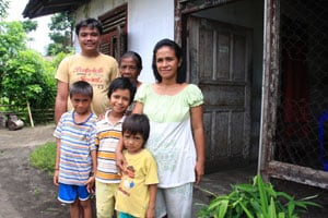 family of six people standing outside a home