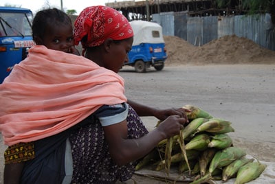 woman with stack of ears of corn