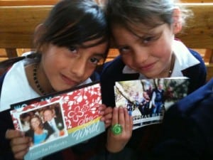 two young girls holding photos
