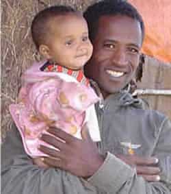 smiling man holding baby in his arms
