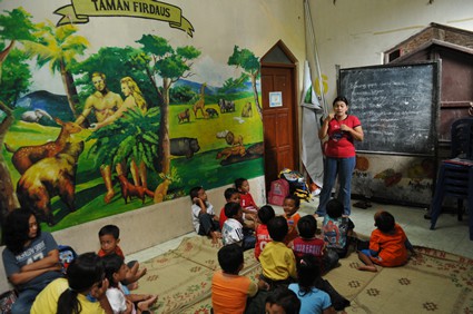 woman in a classroom instructing small children
