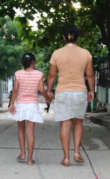 A woman and girl walking together and holding hands