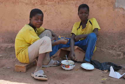 two boys in yellow shirts sharing a meal