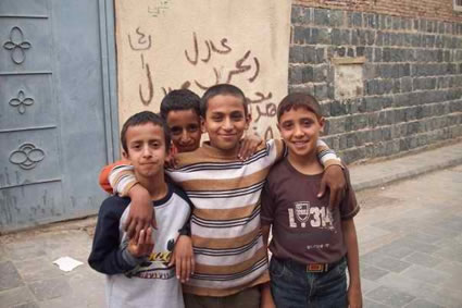 group of four boys with boy putting his arms around two of them