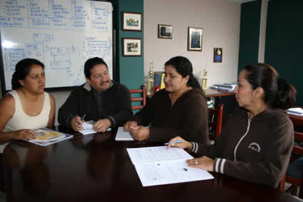 three women and one man sitting around office table
