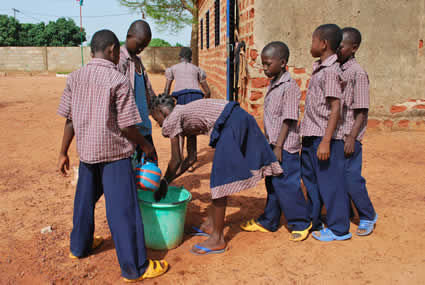 children outside washing hands