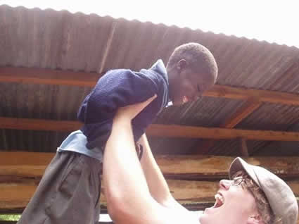 Young man bursting with joy holding a young boy with a huge smile over his head
