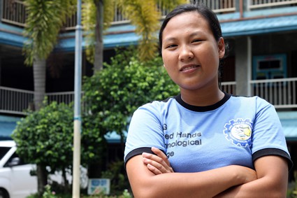 Young girl standing outside of a building.