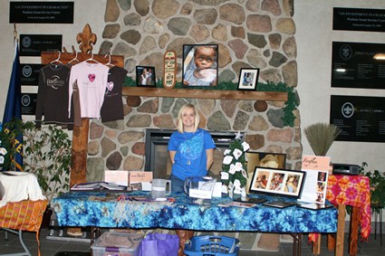 girl standing at a table with several products for sale