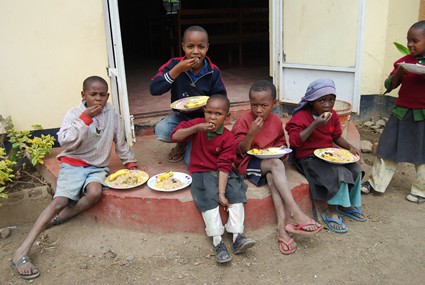 group of children sitting outside eating lunch