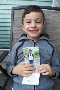 young boy holding a picture of a child