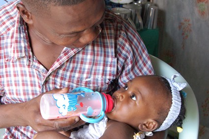 man bottle feeding a baby