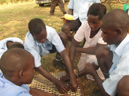 woman teaching children how to weave baskets