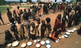 Refugee children with bowls of porridge.