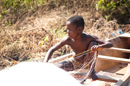 boy working with a fishing net in a boat