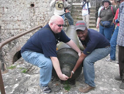 two men trying to lift cannon