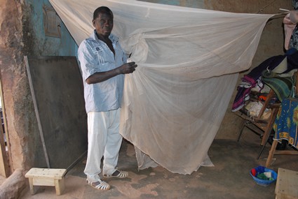 man holding malaria net