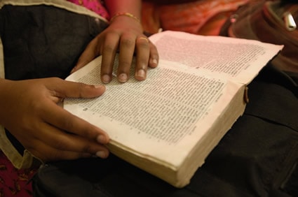childs hand on open bible