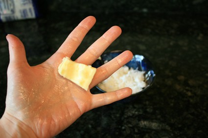 person rubbing butter into hand