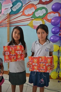 Two girls holding present.