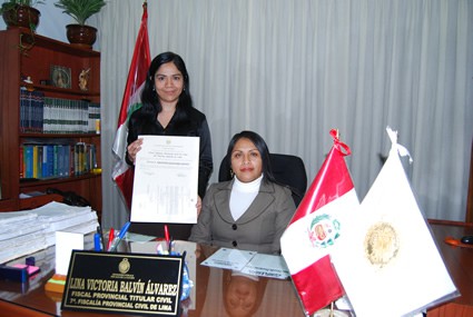 woman sitting at desk with a younger woman holding a certificate