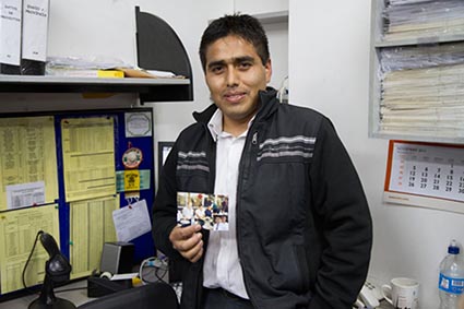 man standing in office holding a photo