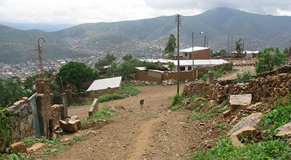 dirt road with village in the background