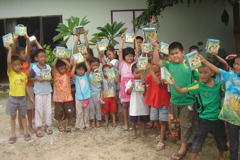 Many young children holding bibles.