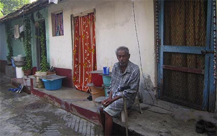 man sitting outside of house next to door