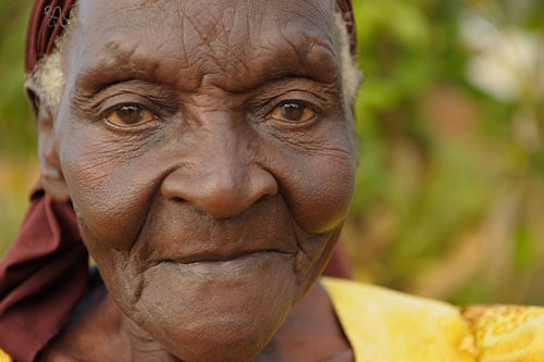 An elderly woman looks at the camera