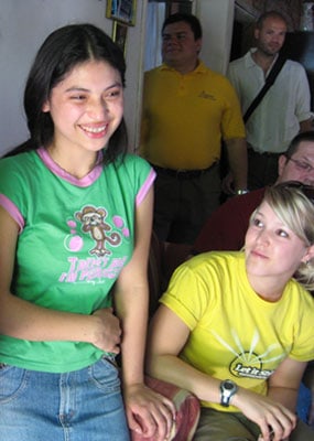 smiling girl in green shirt next to young woman