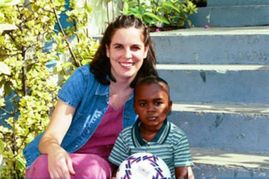 a young woman with her arm around a serious boy holding a soccer ball