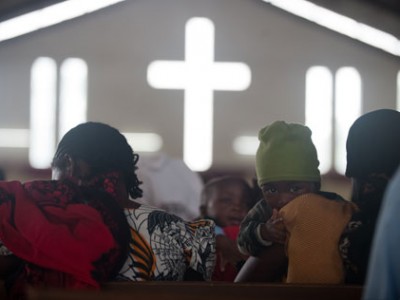 people inside a church with a cross in front of them