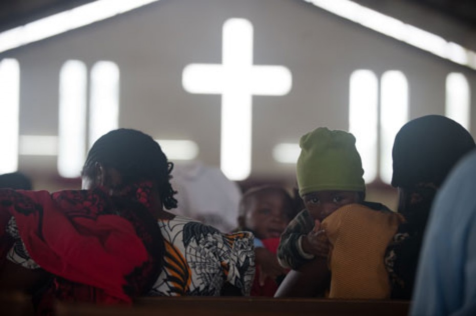 people inside a church with a cross in front of them