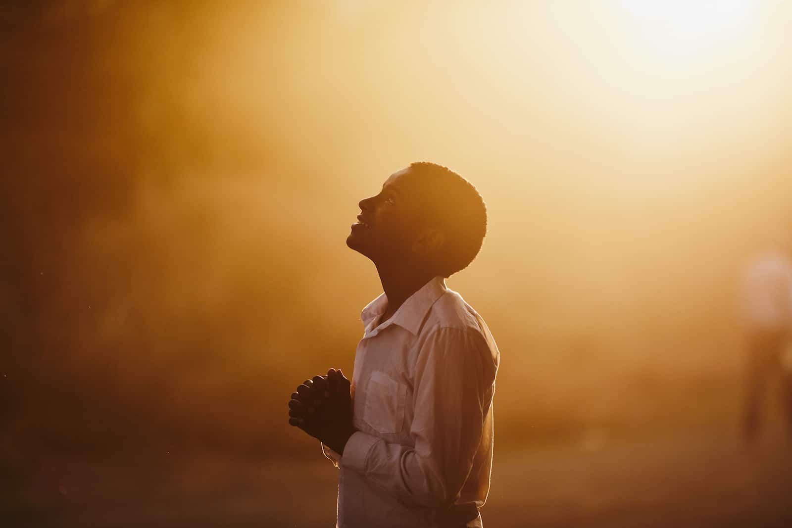 A boy looks up into the sky, with a happy look on his face.