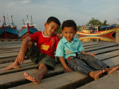 two boys sitting on dock